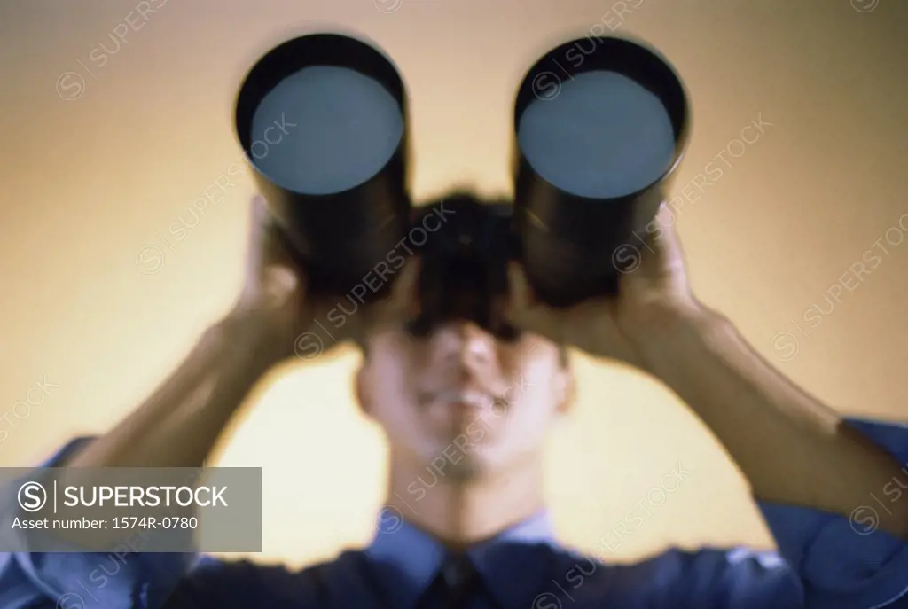 Businessman looking through a pair of binoculars