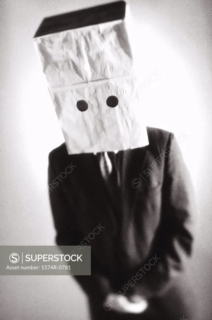 Businessman standing with a paper bag over his head