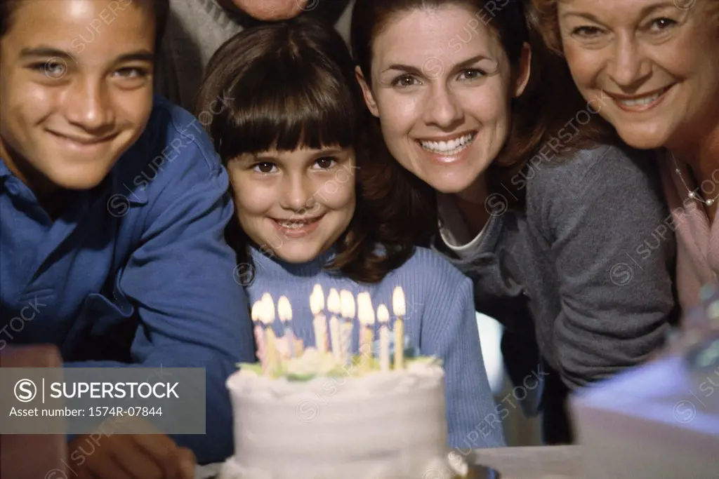 Portrait of a family smiling in front of a cake