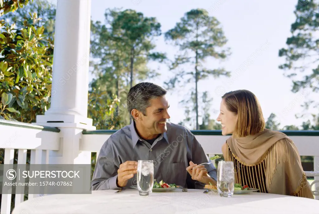 Mid adult couple sitting at a table outdoors