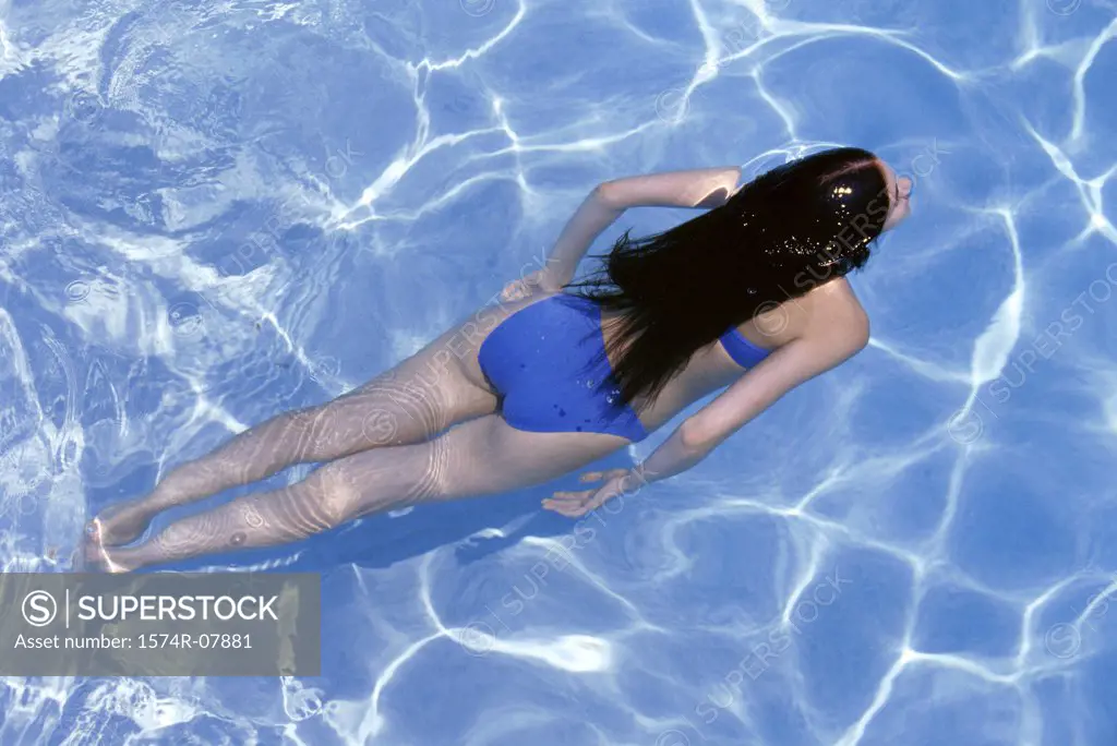 High angle view of a young woman swimming in a swimming pool