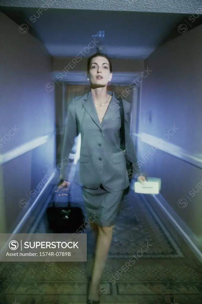 Portrait of a businesswoman walking with a stroller in a corridor