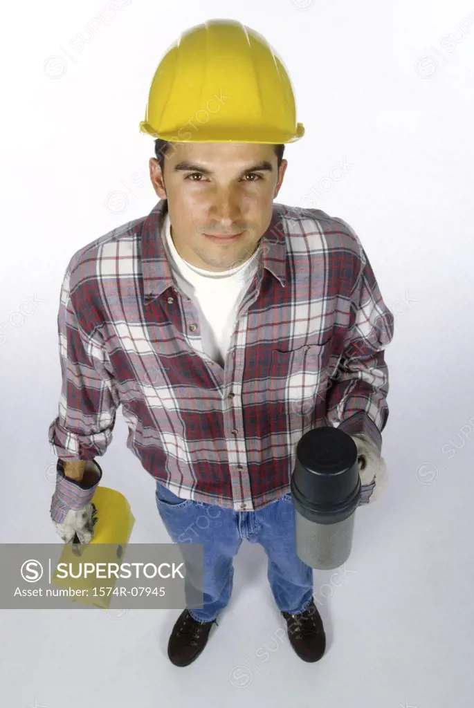 Portrait of a construction worker holding a lunchbox and a thermos