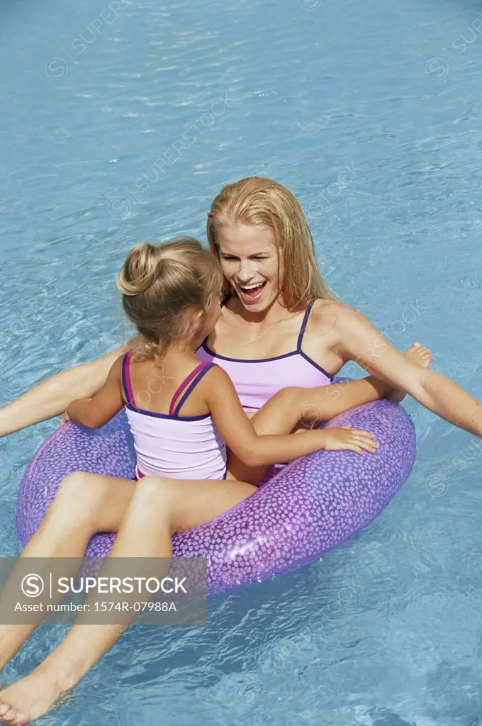 Mother and her daughter playing in a swimming pool