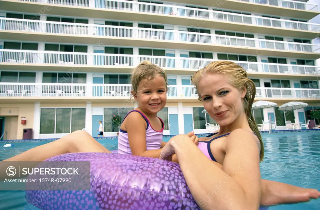 Portrait of a mother and her daughter playing in a swimming pool
