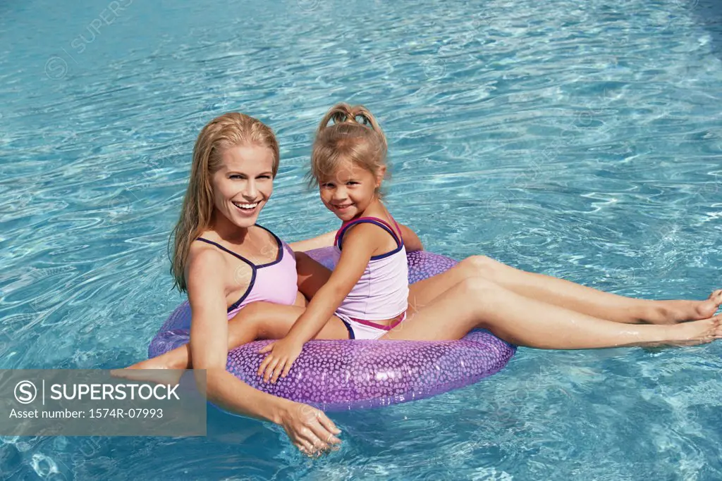 Portrait of a mother and her daughter playing in a swimming pool