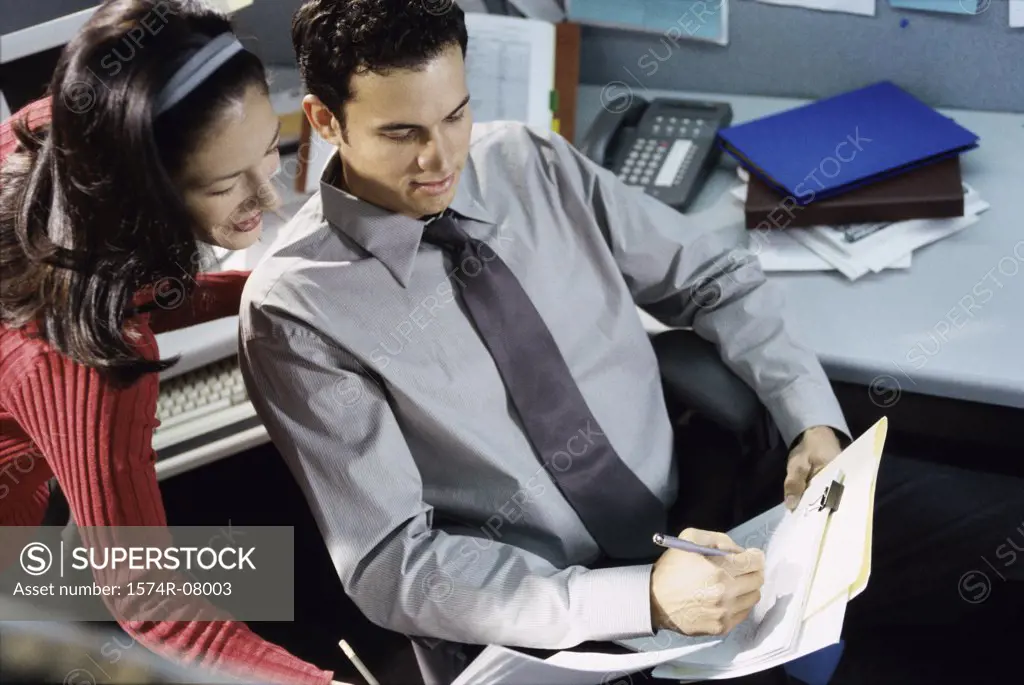 High angle view of a businessman and a businesswoman discussing a report.