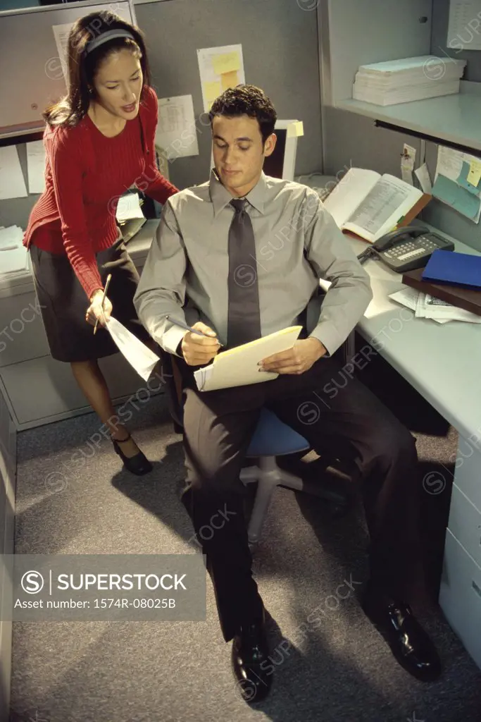 High angle view of a businessman and a businesswoman discussing a report
