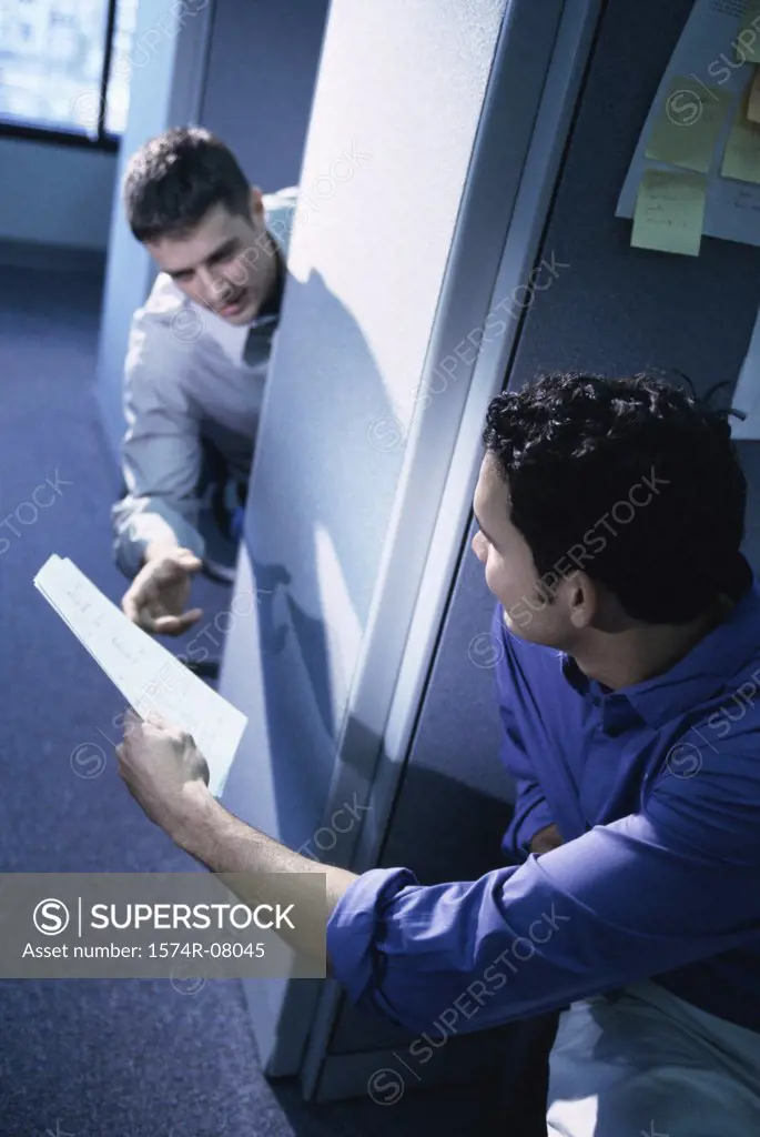 Businessman handing another businessman documents in an office