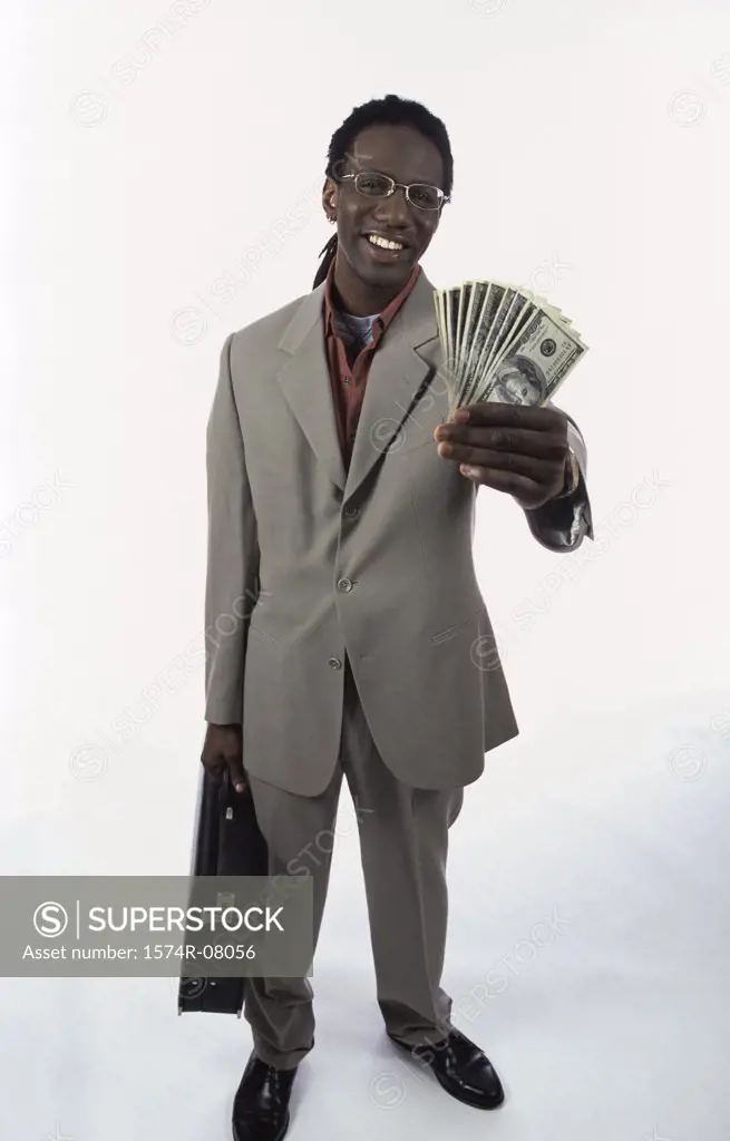 Portrait of a young man holding paper money and a briefcase