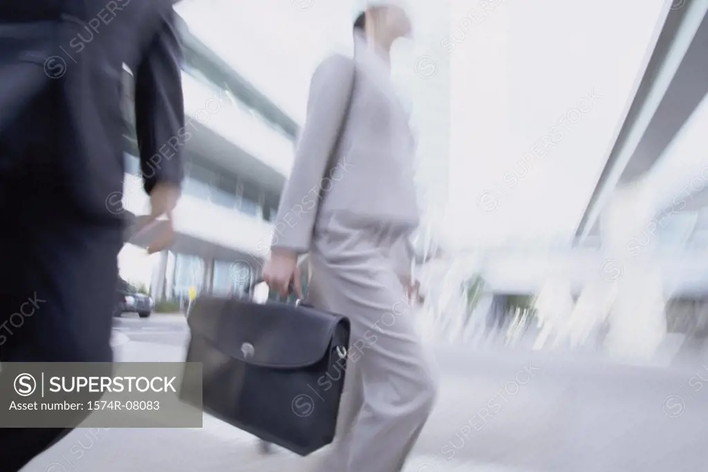 Low angle view of a businessman and a businesswoman walking