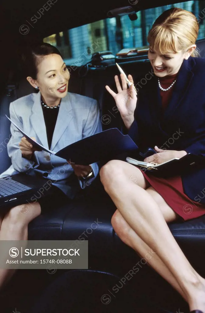 Two businesswomen discussing in a car