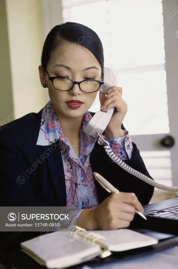 Businesswoman talking on a landline telephone at her desk