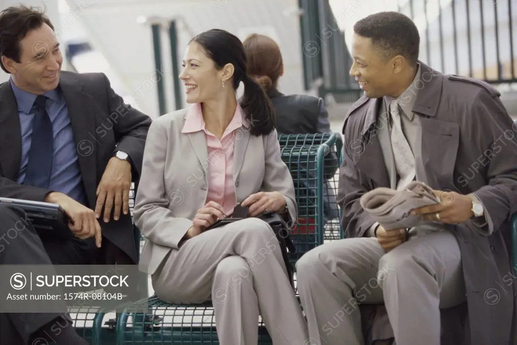 Two businessmen and a businesswoman sitting together