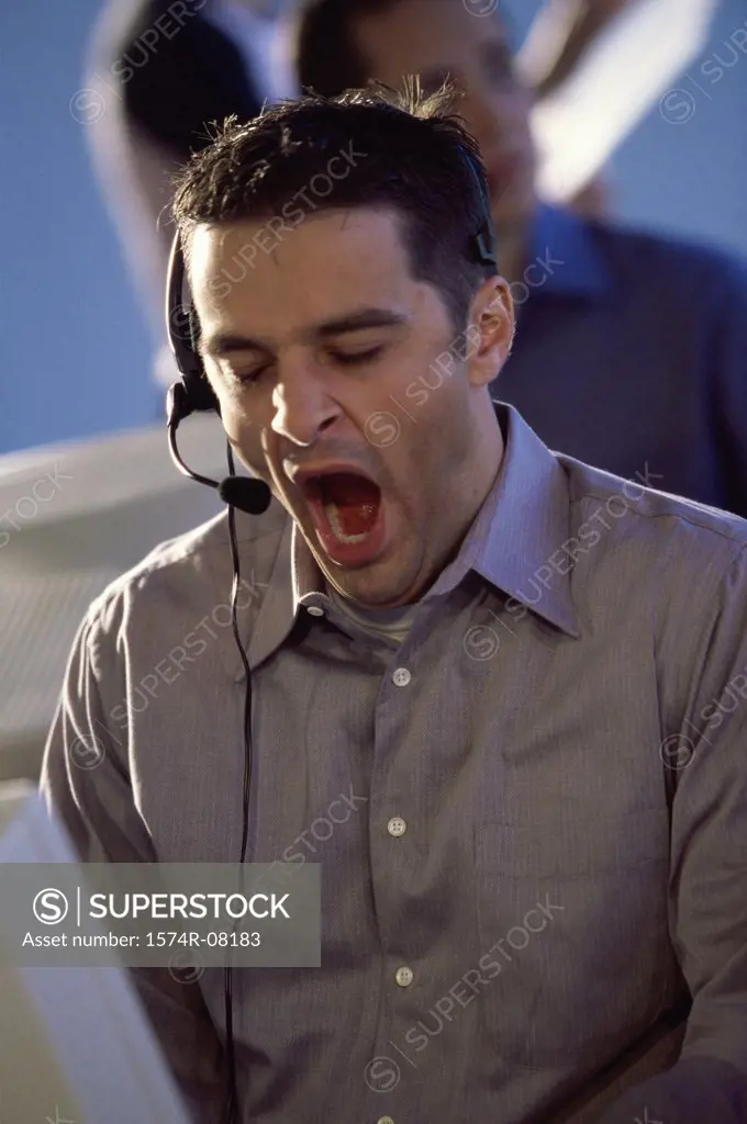 Customer service representative wearing a headset yawning