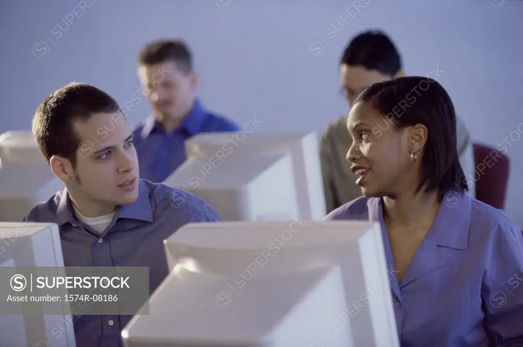People sitting in front of computer monitors