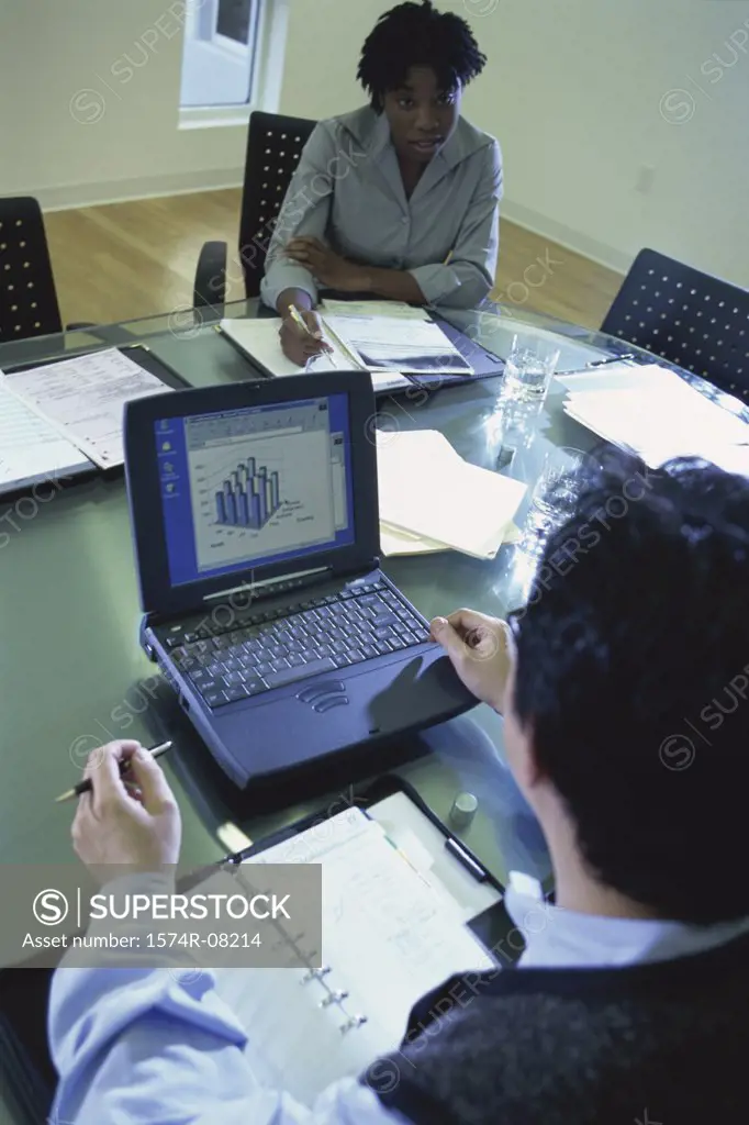 High angle view of a businessman and a businesswoman sitting in a conference room