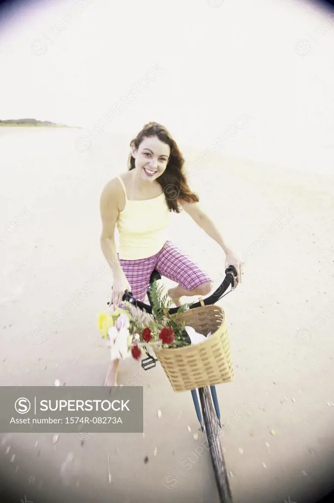 Portrait of a young woman cycling on the beach