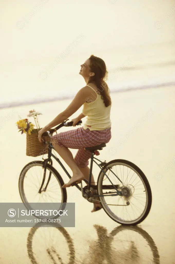 Young woman riding a bicycle on the beach