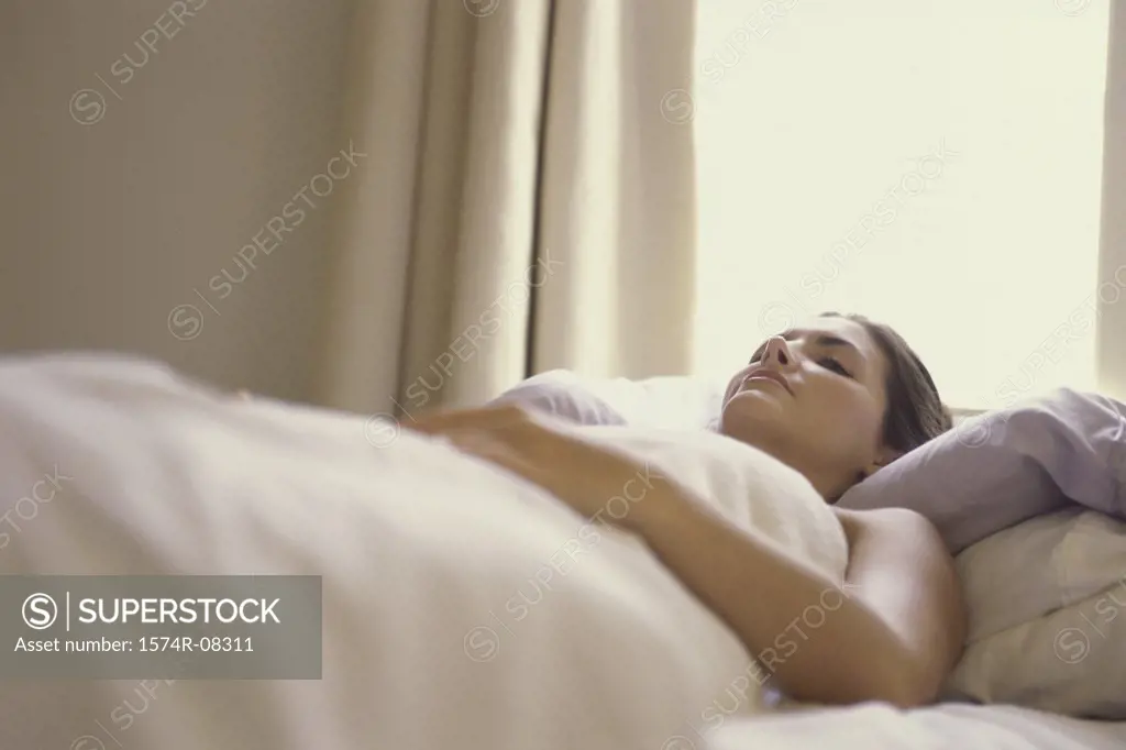 Low angle view of a young woman sleeping on a bed