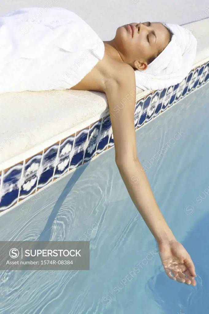 High angle view of a young woman lying near a swimming pool