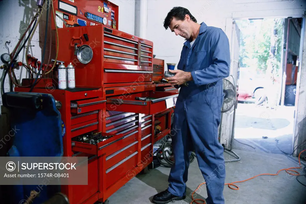 Auto mechanic standing near a toolbox in a garage