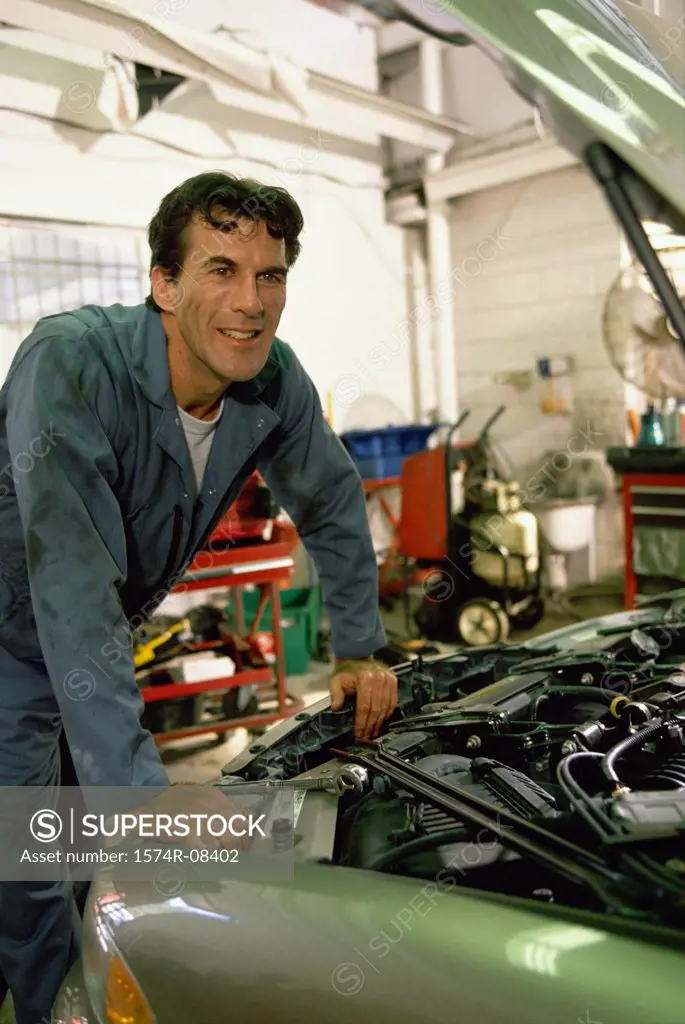 Auto mechanic working over the engine bay of a car