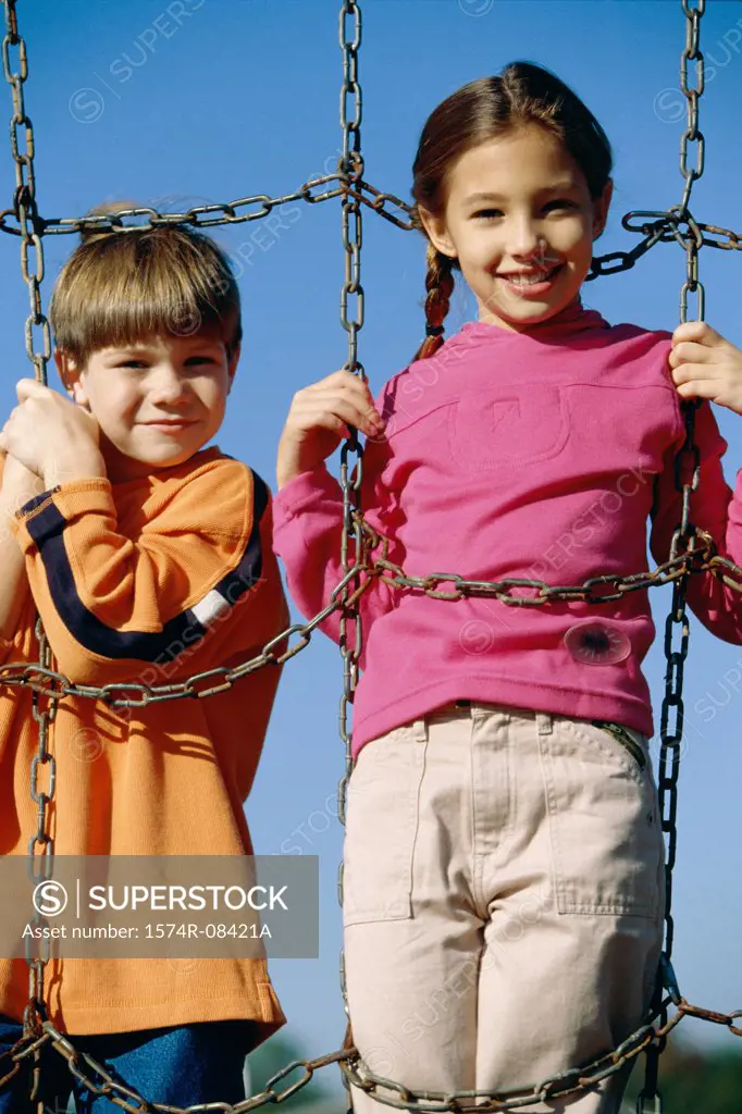Portrait of two children playing on a jungle gym