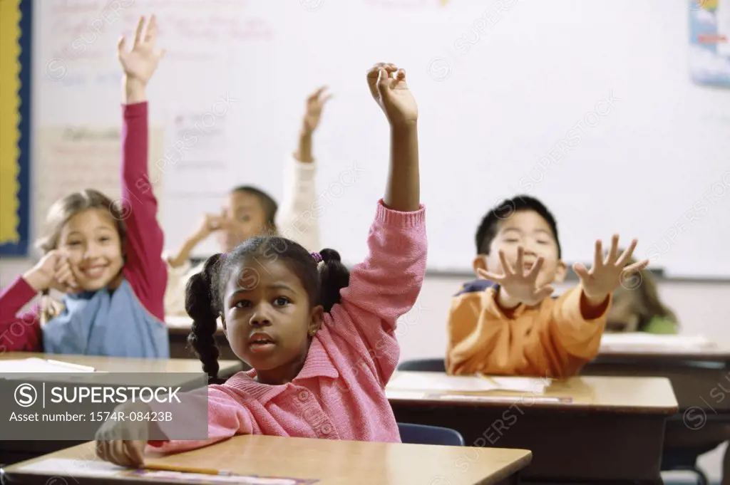 School children raising their hands in class