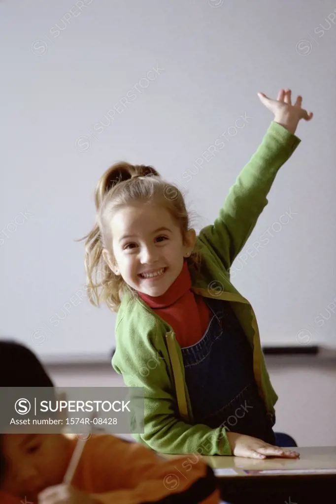 Portrait of a girl raising her hand in class