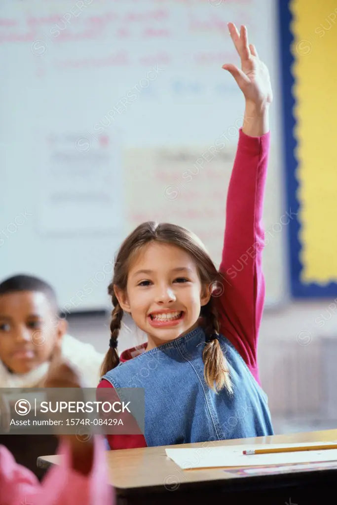 Portrait of a girl raising her hand in class