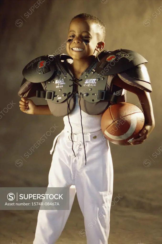Boy in a football uniform holding a ball