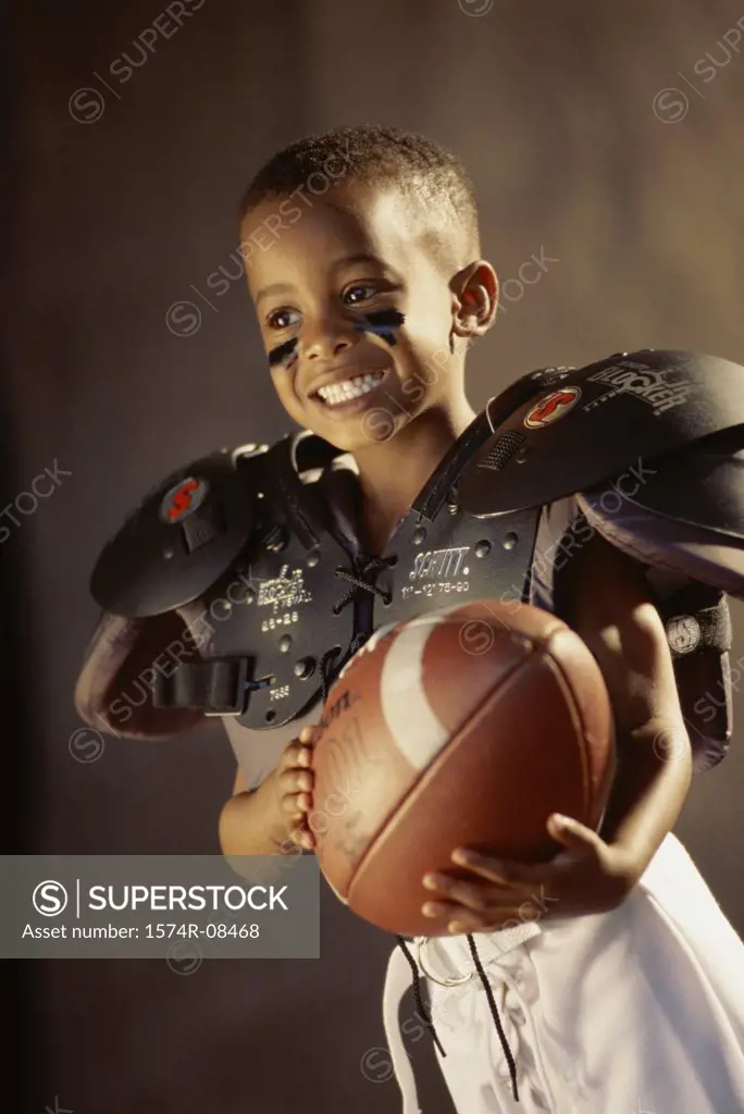 Boy in a football uniform holding a ball
