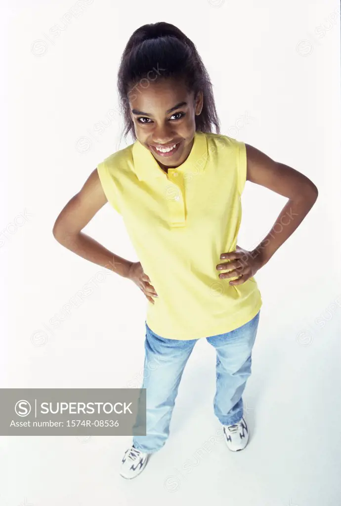High angle view of a teenage girl standing with her hands on her hips
