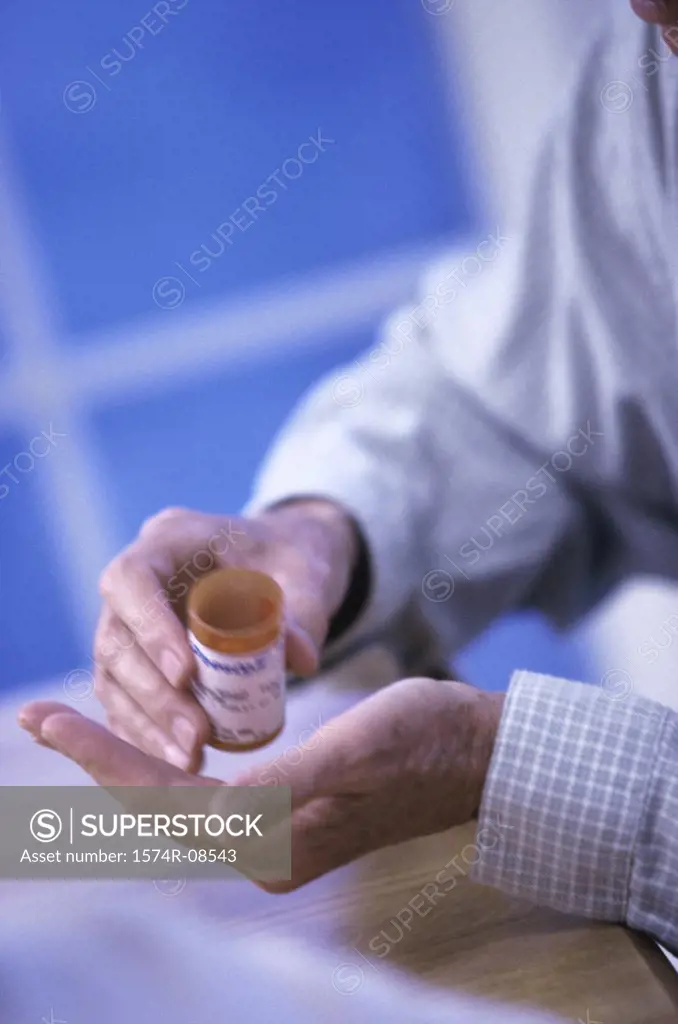 Close-up of a person holding a bottle of pills