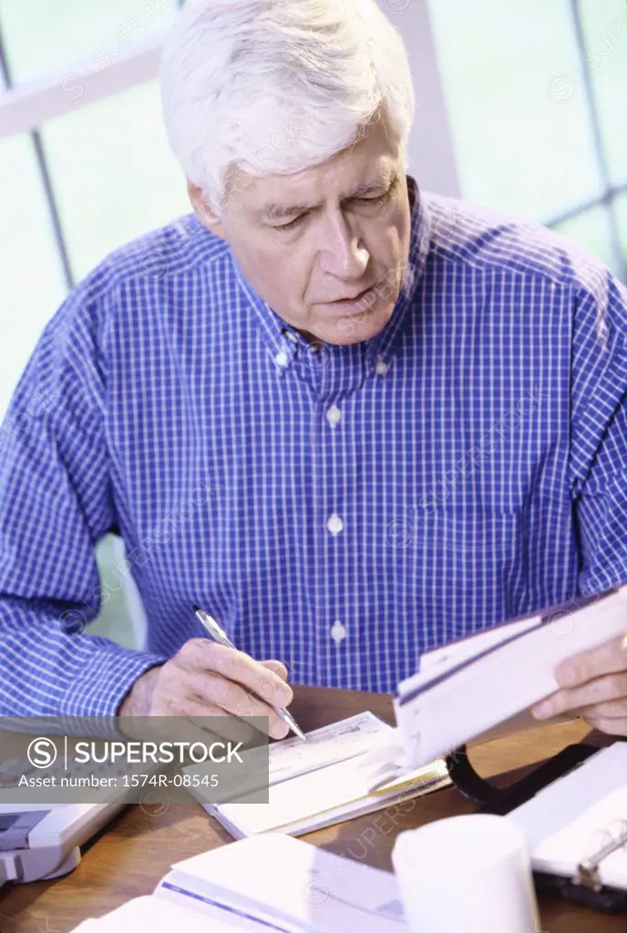 Senior man writing a check