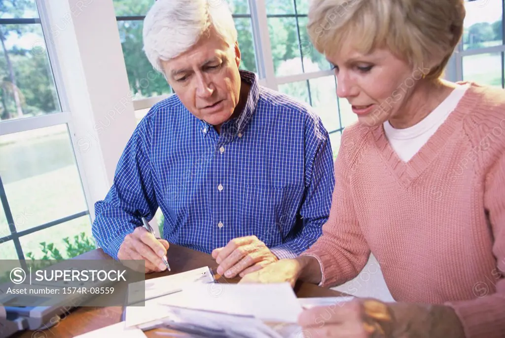 Senior couple sitting together calculating bills