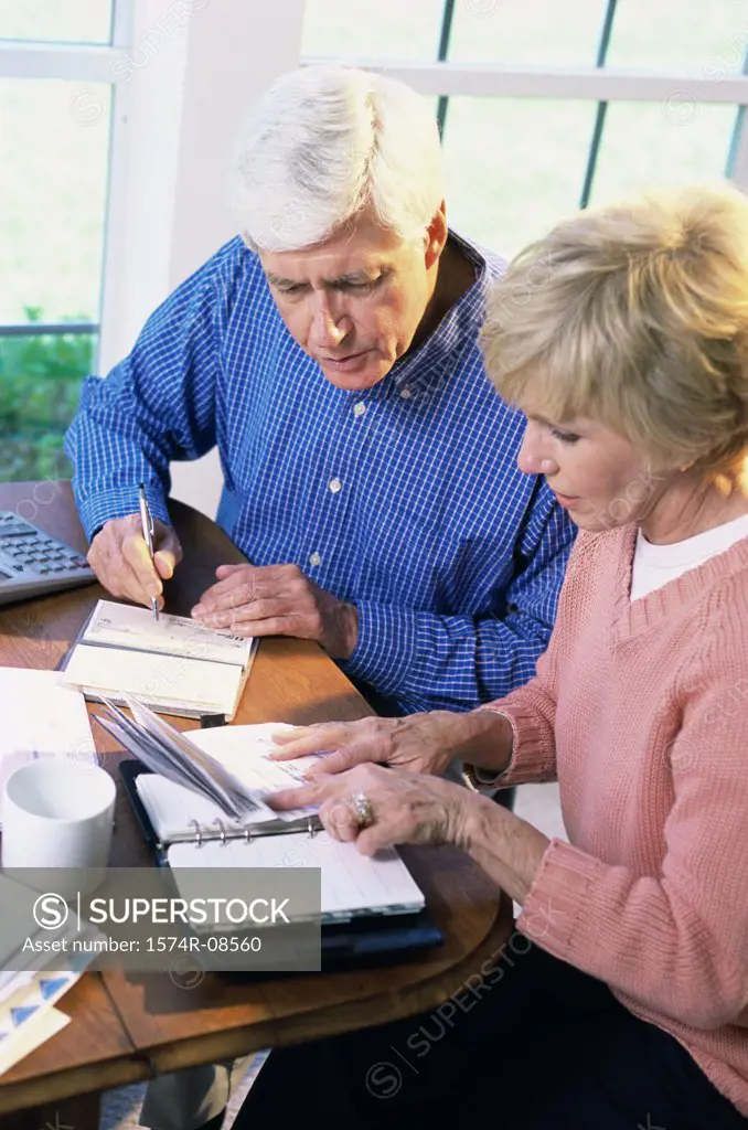 Senior couple sitting together calculating bills
