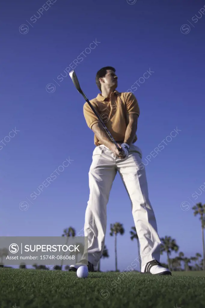 Low angle view of a young man playing golf