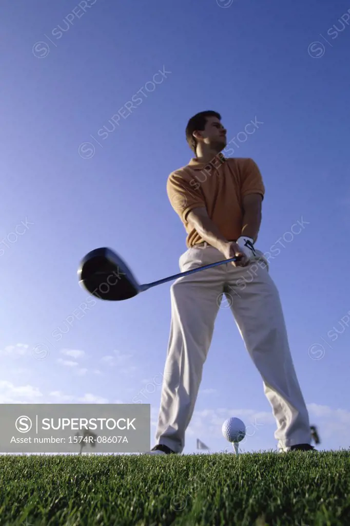 Low angle view of a young man playing golf