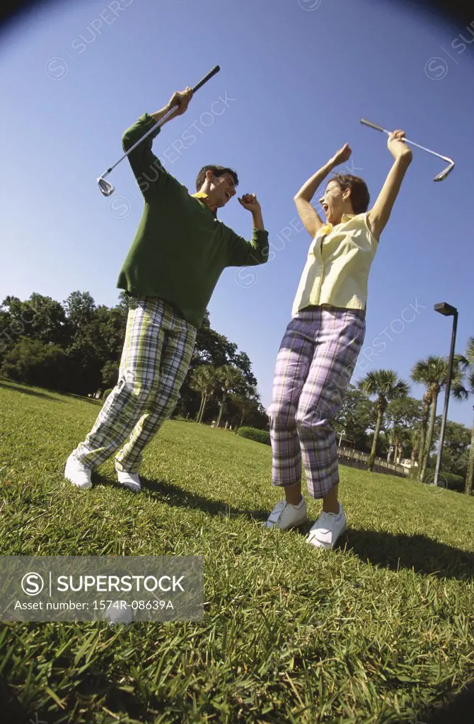 Low angle view of a mid adult man and a mid adult woman at a golf course