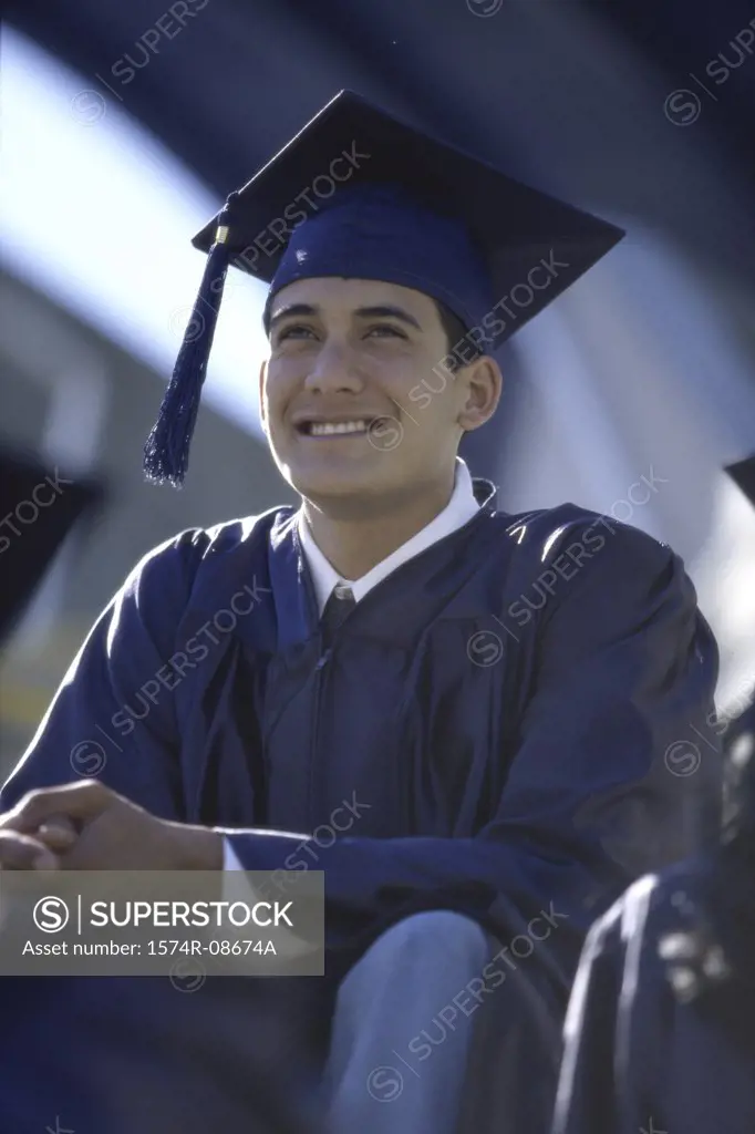 Low angle view of a young male graduate smiling