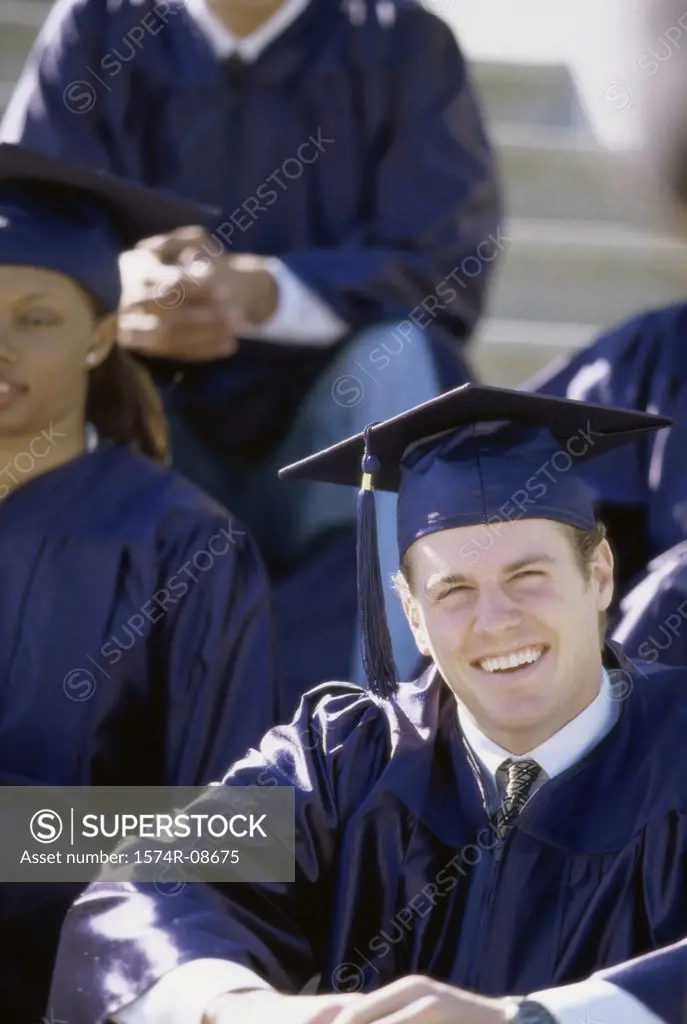 Young male graduate smiling