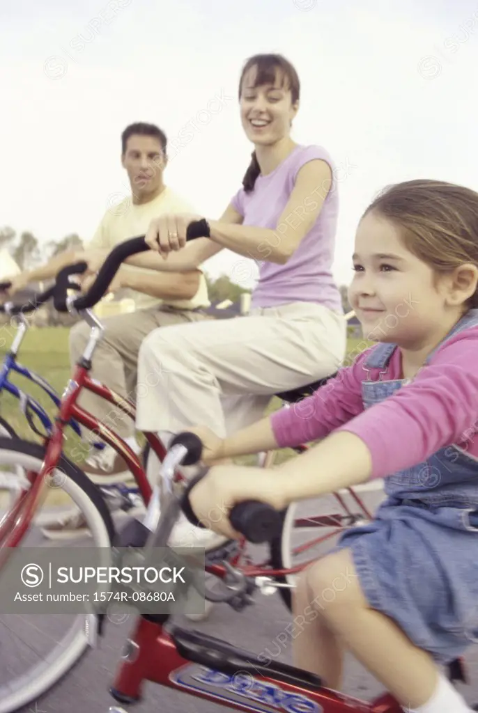 Young couple cycling with their daughter