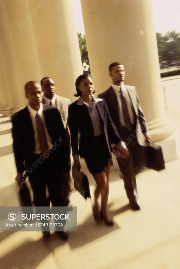 High angle view of three businessmen and a businesswoman walking together