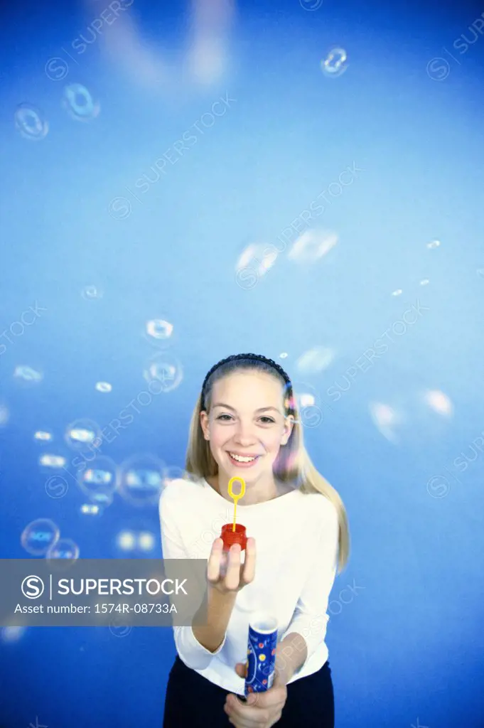 Portrait of a teenage girl playing with a bubble wand