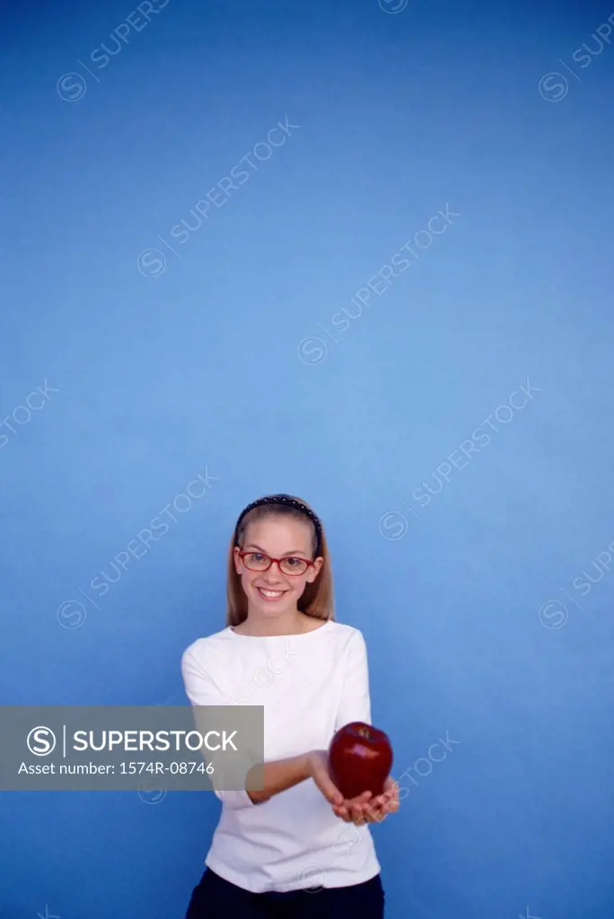 Portrait of a teenage girl holding an apple