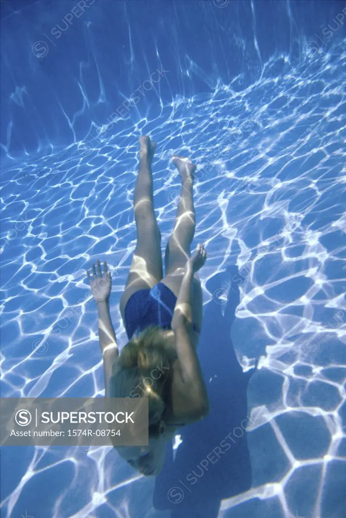 Young woman swimming underwater in a swimming pool