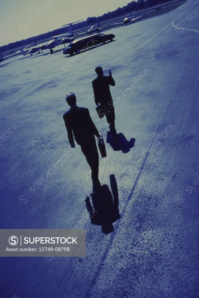 Rear view of two businessmen walking in an airport