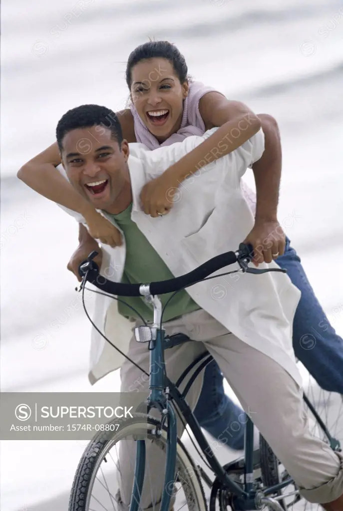 Portrait of a young couple on a bicycle at the beach